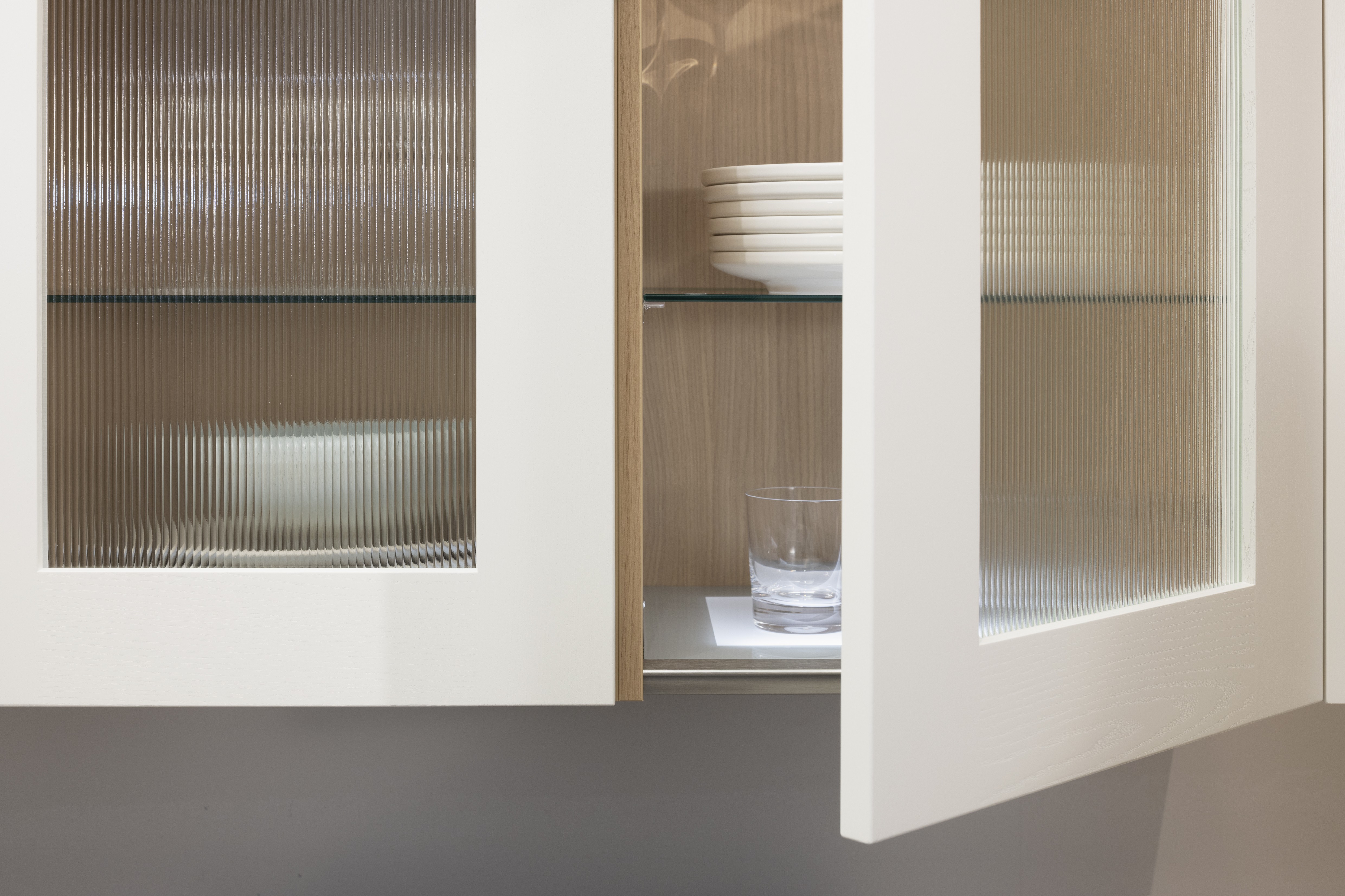 Häcker-Küche Systemat moderne Landhausküche in Weiß mit Kalkstein und Wildeiche - Detailansicht Vitrine mit Riffelglas