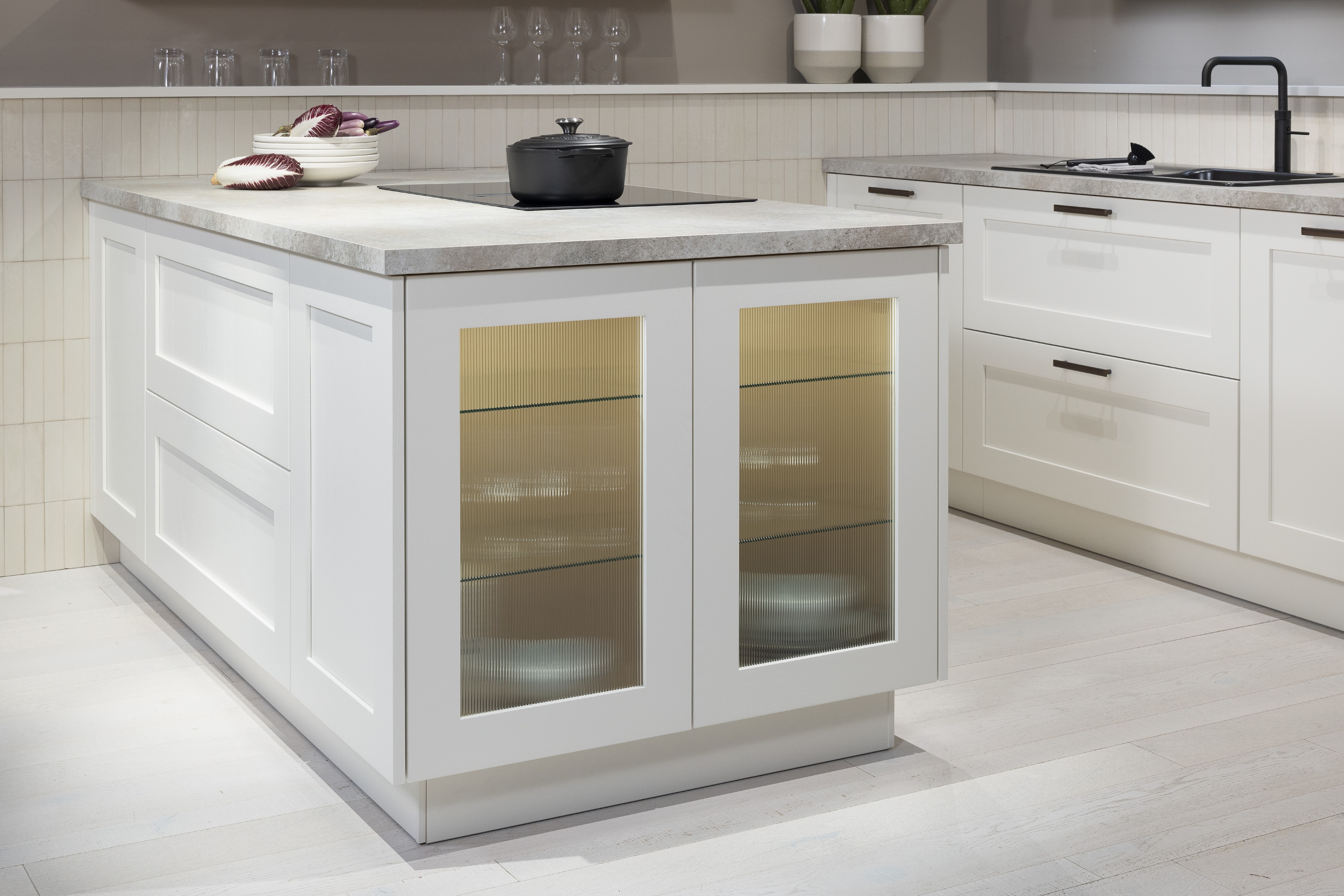 Häcker-Küche Systemat moderne Landhausküche in Weiß mit Kalkstein und Wildeiche - Detailansicht Vitrine seitlich der Kücheninsel