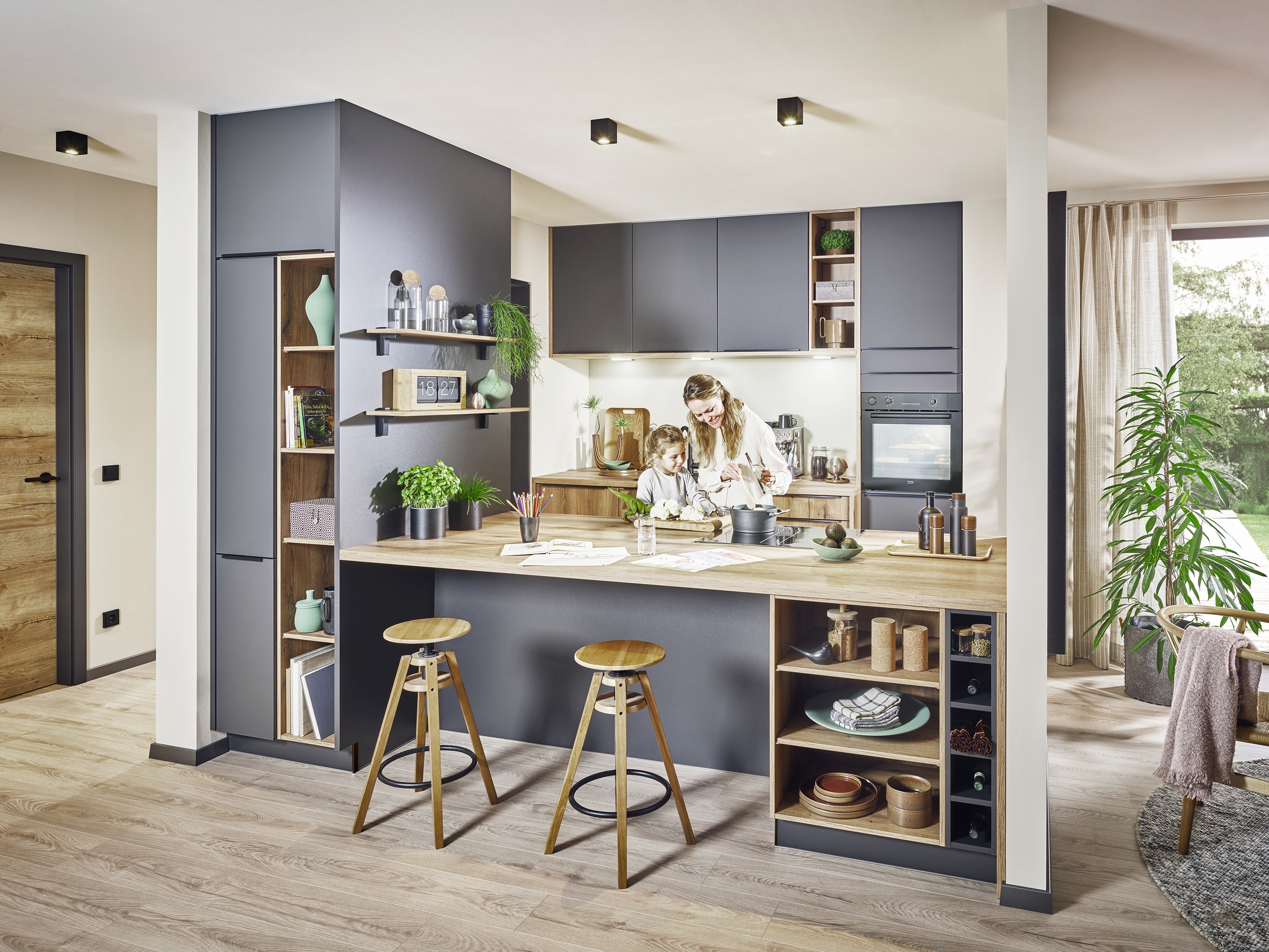 offene Küche in einer Nische zum Wohnbereich hin durch Theke abgegrenzt mit offenen Regalfächern Holz-Grau-Kombination