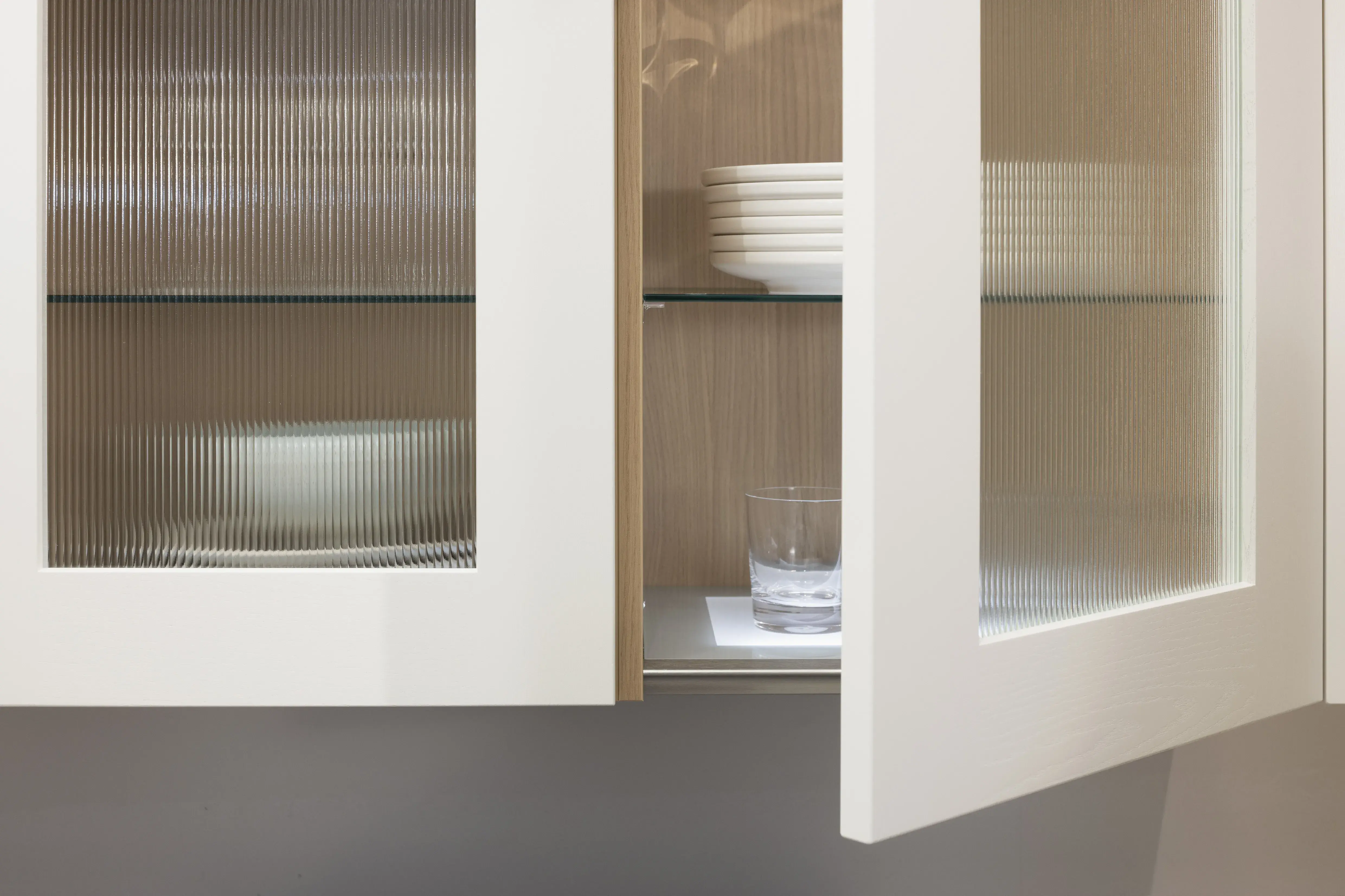 Häcker-Küche Systemat moderne Landhausküche in Weiß mit Kalkstein und Wildeiche - Detailansicht Vitrine mit Riffelglas