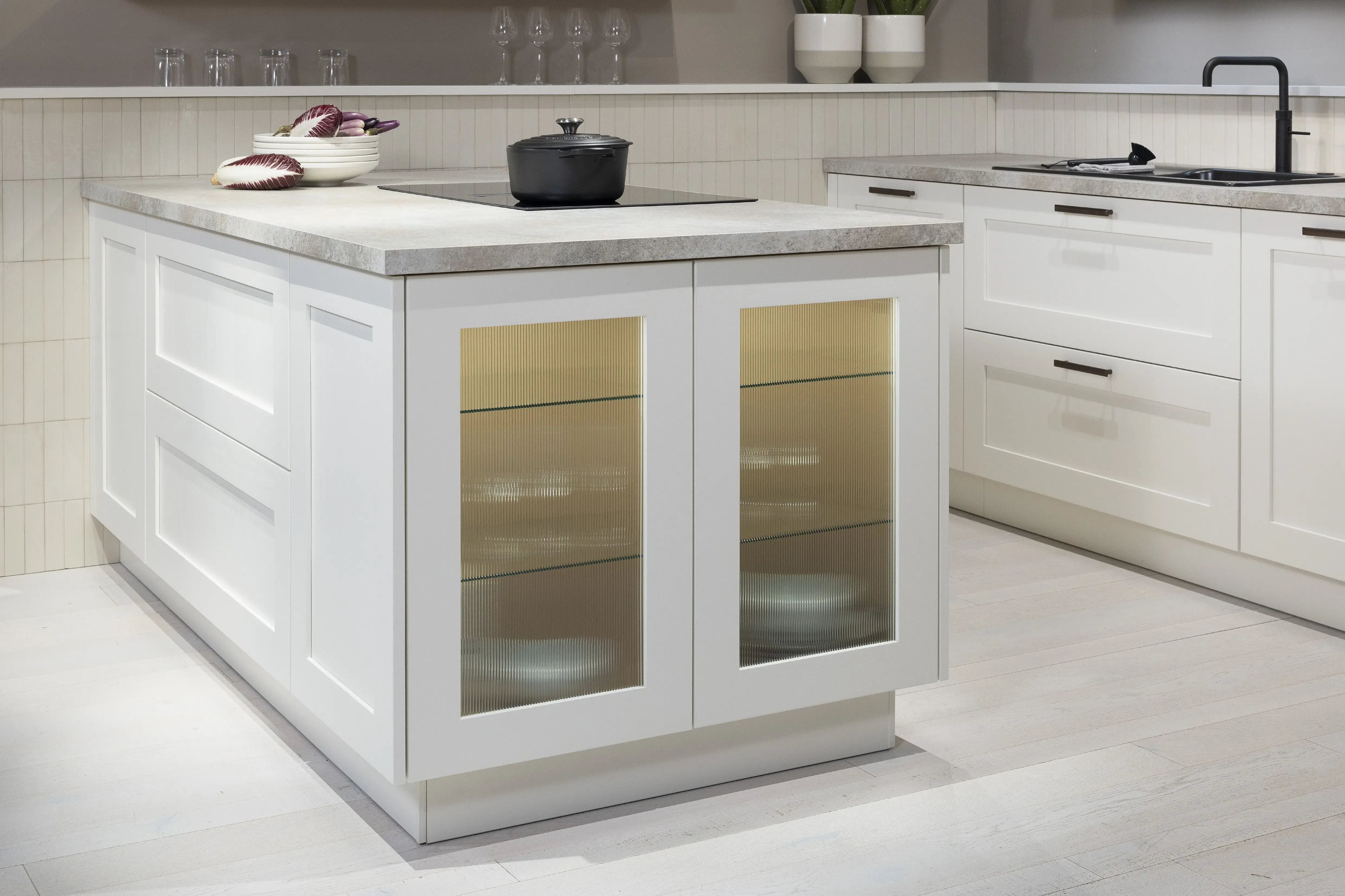 Häcker-Küche Systemat moderne Landhausküche in Weiß mit Kalkstein und Wildeiche - Detailansicht Vitrine seitlich der Kücheninsel