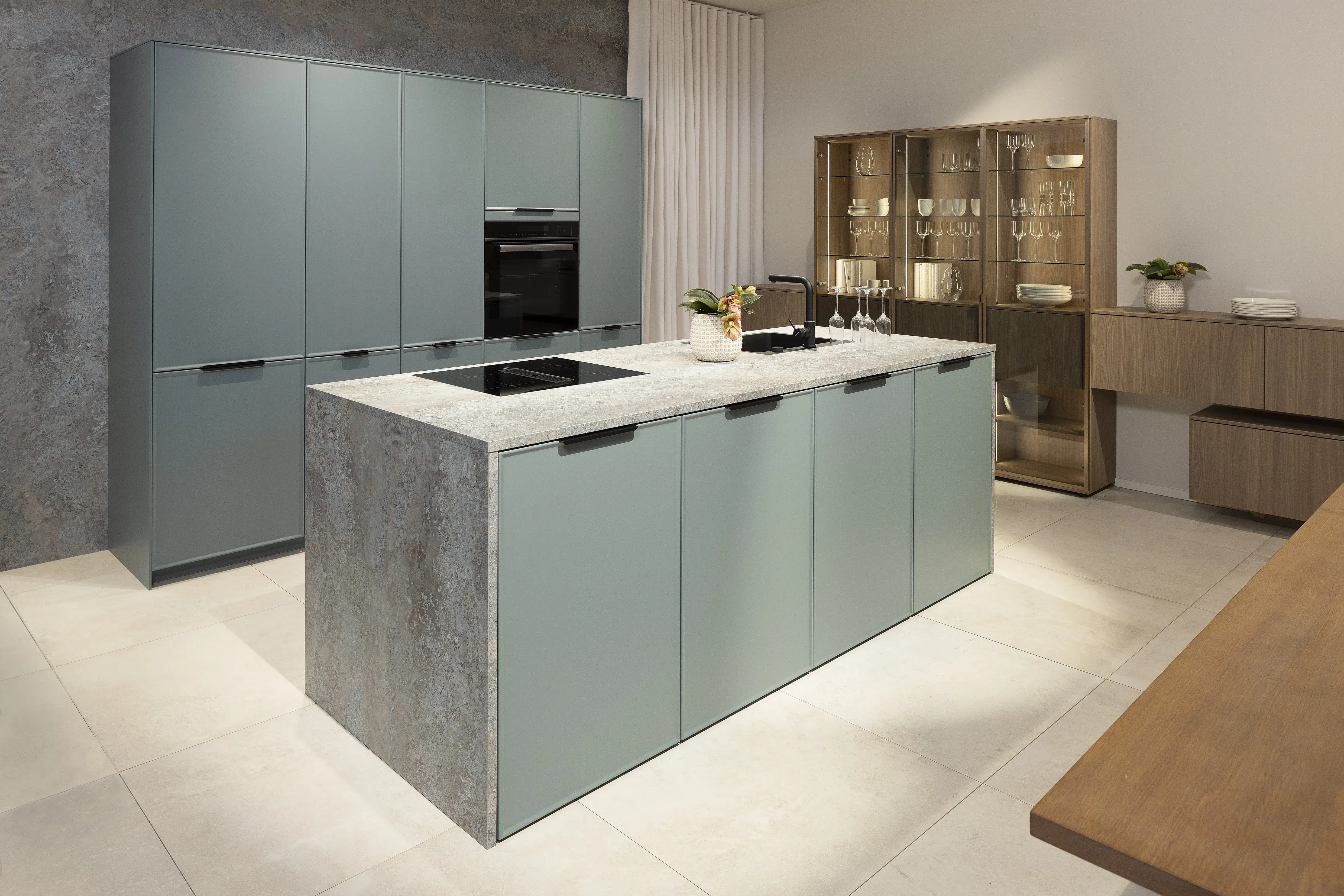 APL: 172 Granit-türkis Repro Front: AV 5075 NCS lackiert Oberfläche Mattlack (PURemission), Kanten umlaufend gerundet Korpus: 2022 Designkorpus Lichtgrau Griff: M791 Schwarz gebürstet Geräte: Blaupunkt Armatur: Blaupunkt Spüle: Blaupunkt  Features: Oberfläche in vielen RAL/NCS-Farben wählbar, Facettentür mit Schweizer Kante, Insellösung mit umlaufender APL (auch Wangenmaterial), Vitrine in AV 2020 Luxor-braun, mit LED-Beleuchtung, mit Sideboardlösung und Sitzecke 