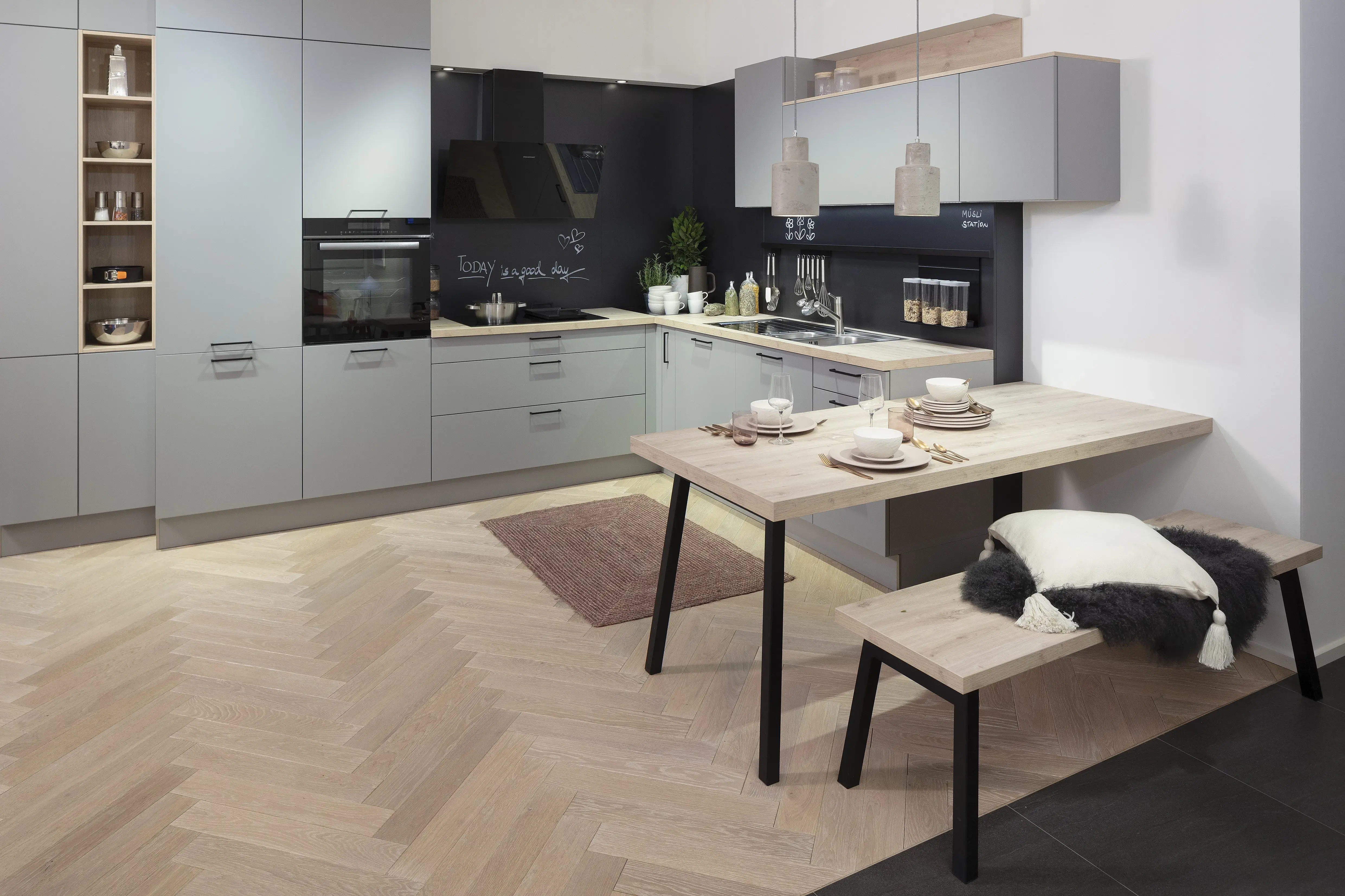 Moderne Küche mit grauen Schränken, Holztisch und gepolsterter Bank